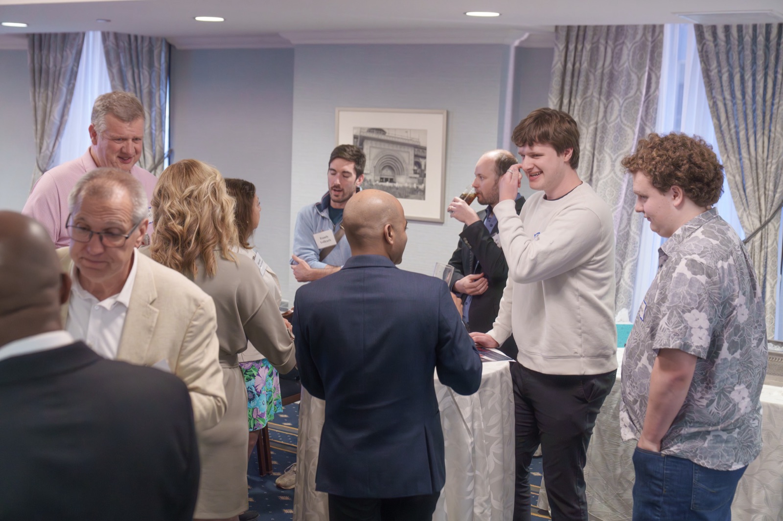 Attendees talking in small groups at a reception.