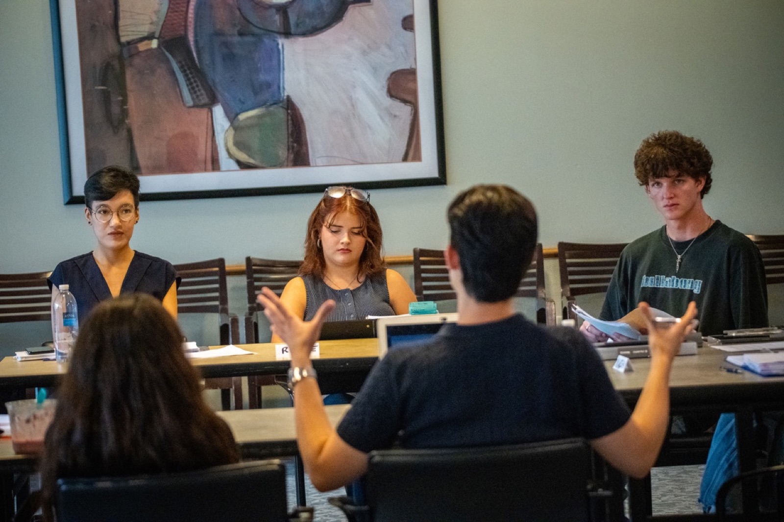 Participants seated around seminar tables during a discussion.
